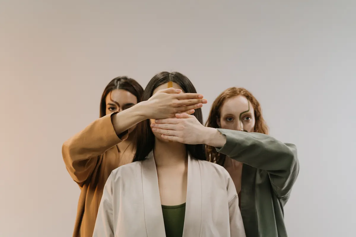 Three women wearing beige, tan and olive tailored jackets